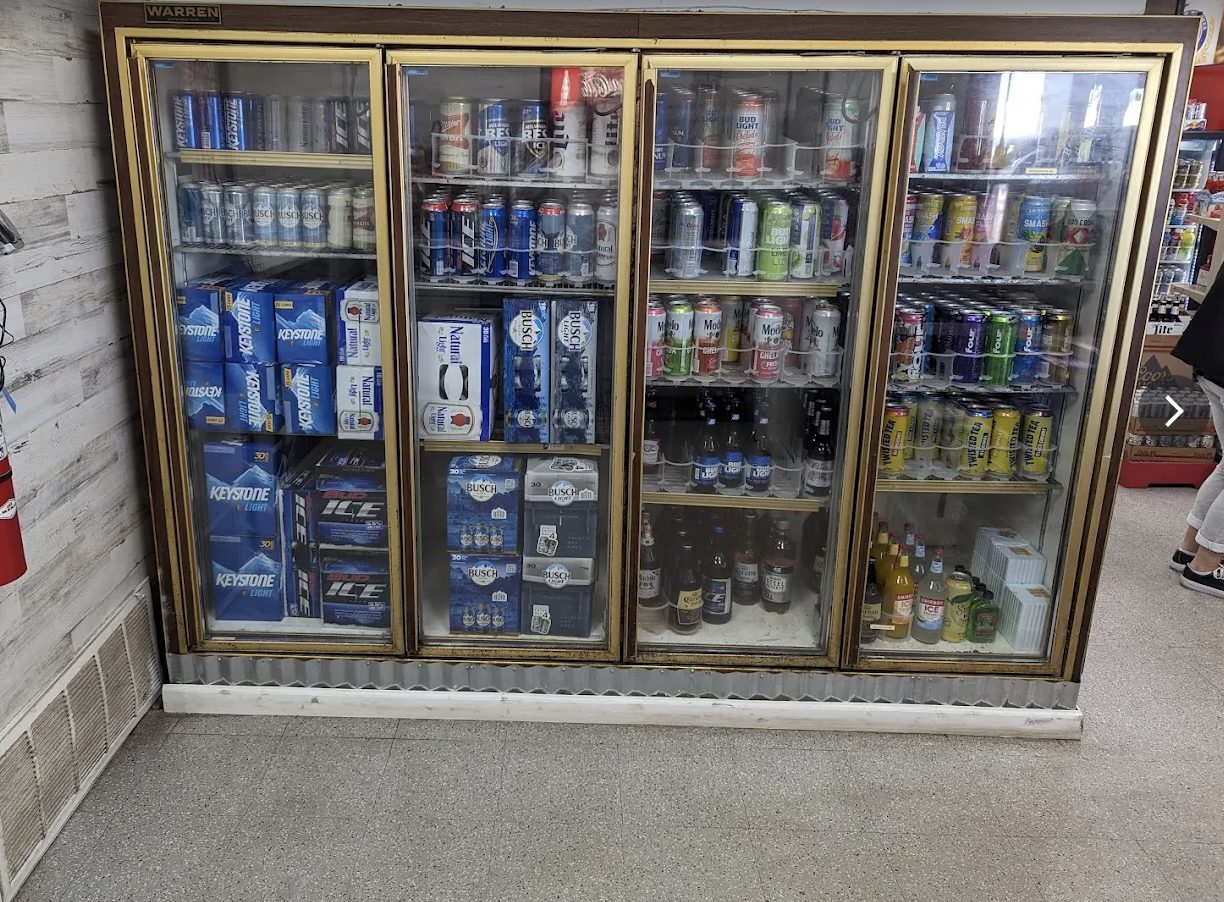 Four-door beer cooler stocked with cases and singles
